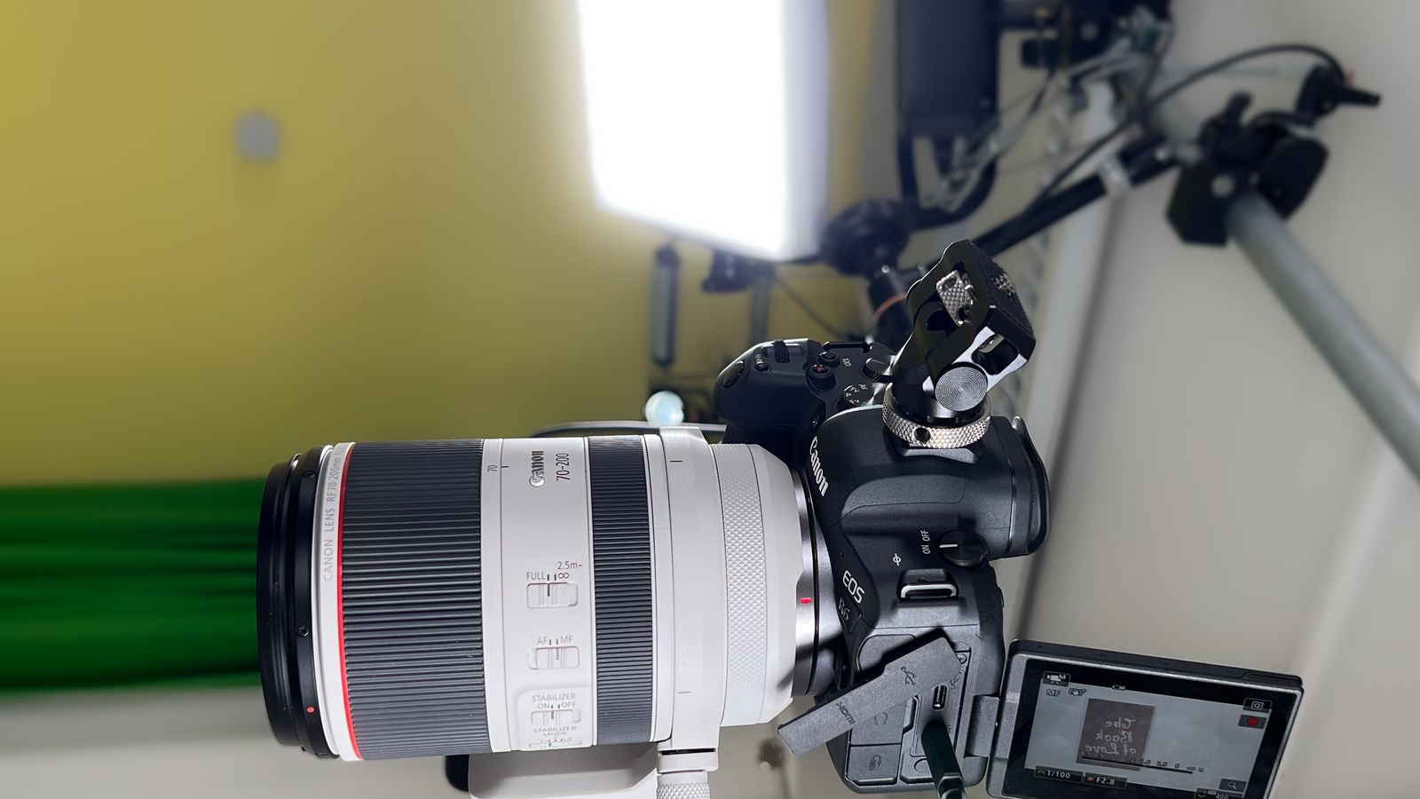 Kamera mit Teleobjektiv im Studio, im Hintergrund Greenscreen und Licht